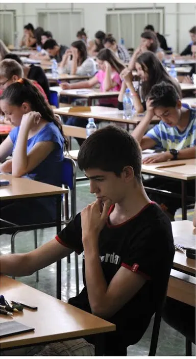 a group of people sitting at desks in a classroom