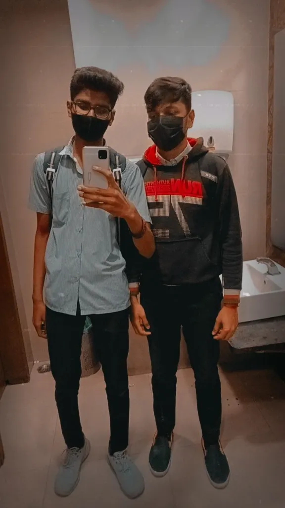 two men standing next to each other in a bathroom