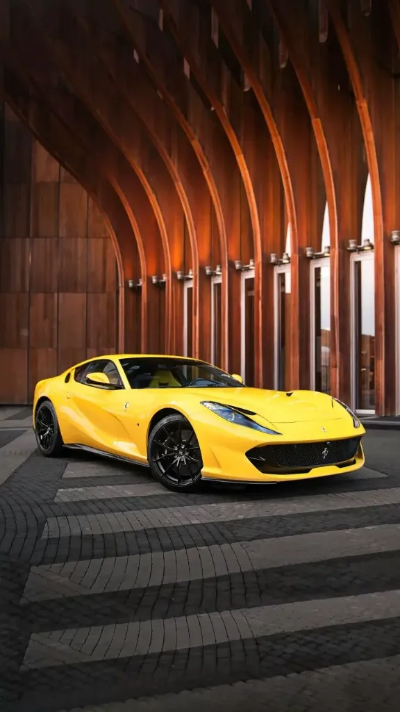 a yellow sports car parked in front of a building
