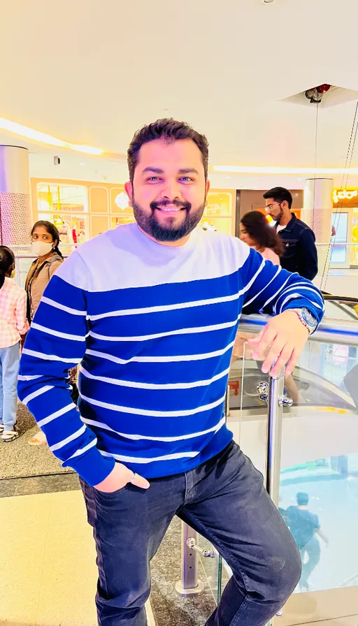 a man in a blue and white striped sweater posing for a picture