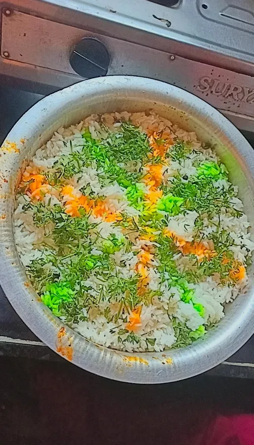 a bowl filled with rice and vegetables on top of a stove