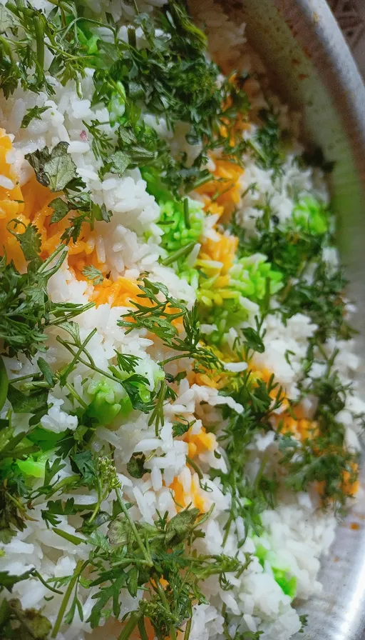 a bowl filled with rice and vegetables on top of a table