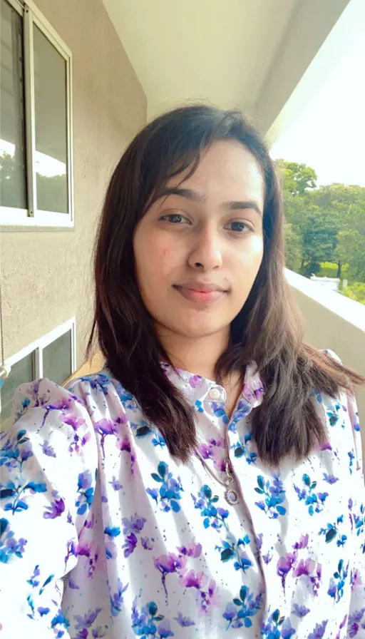 a woman standing on a porch in a flowered shirt