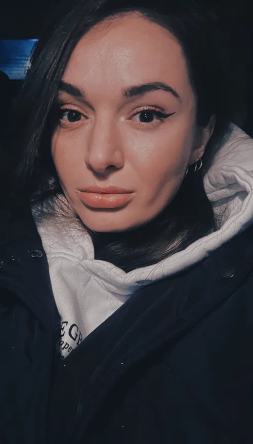a woman in a black jacket and white hoodie