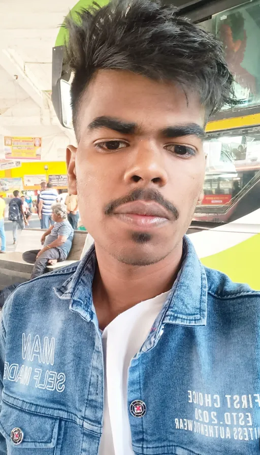 a man with a moustache standing in front of a bus