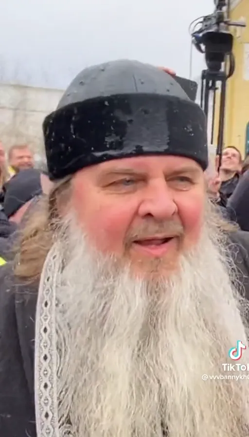 a man with a long beard wearing a black hat