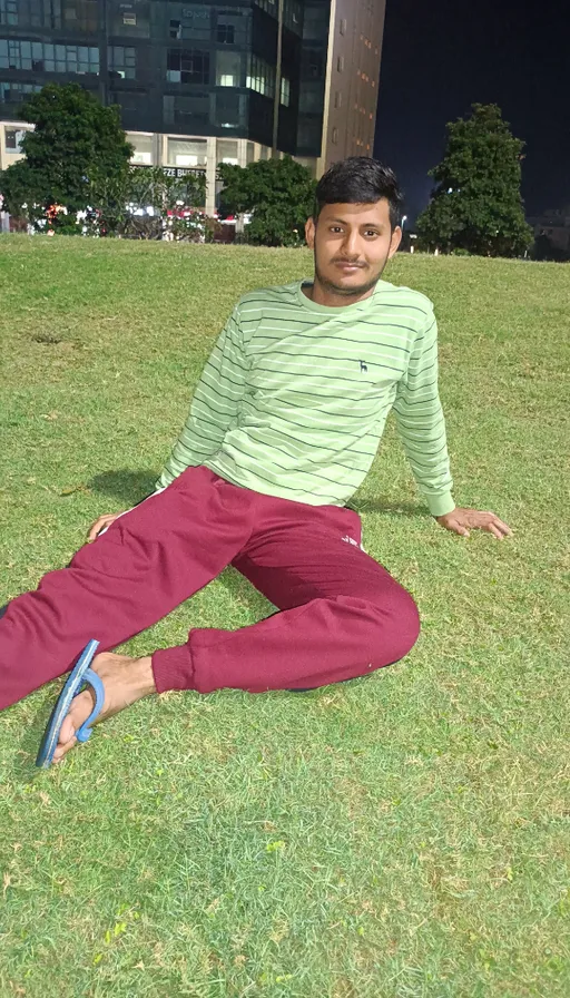 a man sitting on the ground in a field