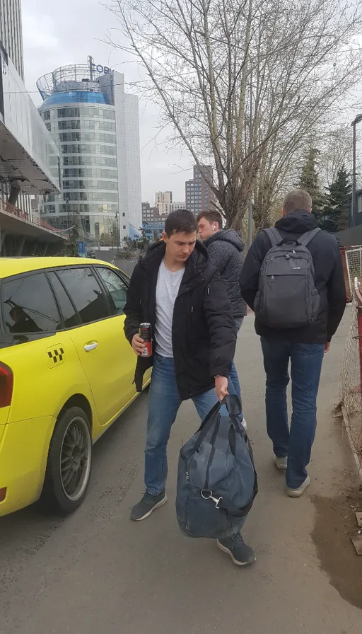 a group of people walking down a street next to a yellow car