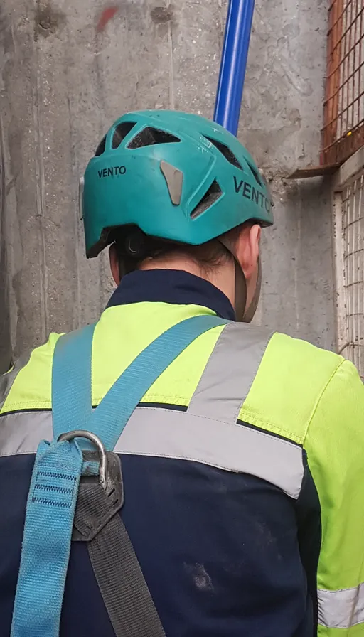 remove the safety vest and helmet and make the man look like he's about to take flight