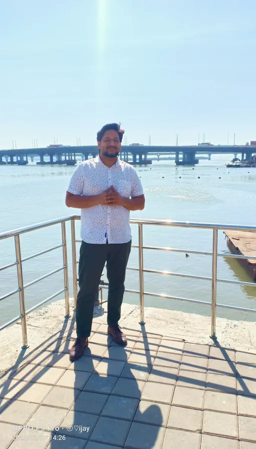 a man is standing on a railing by the water