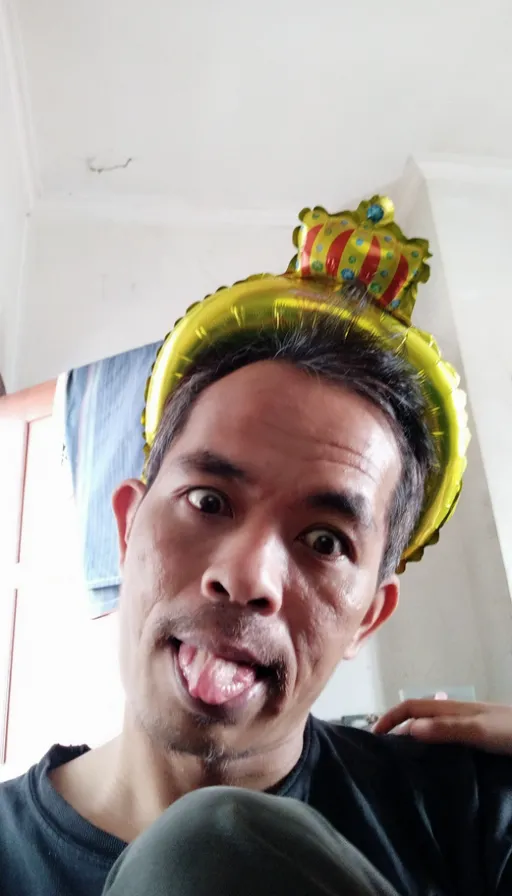 a man with a crown on his head sticking out his tongue