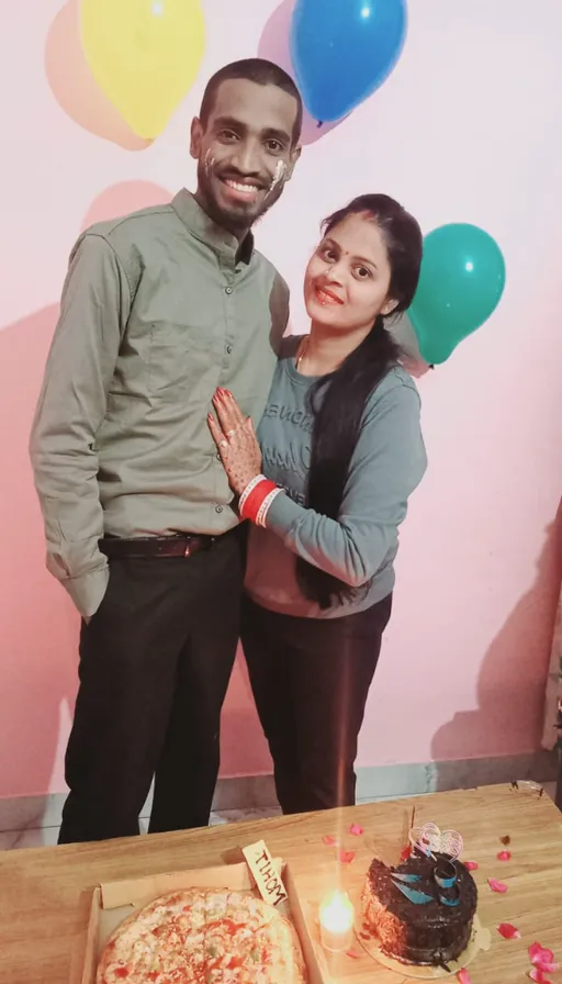 a man and woman standing in front of a birthday cake