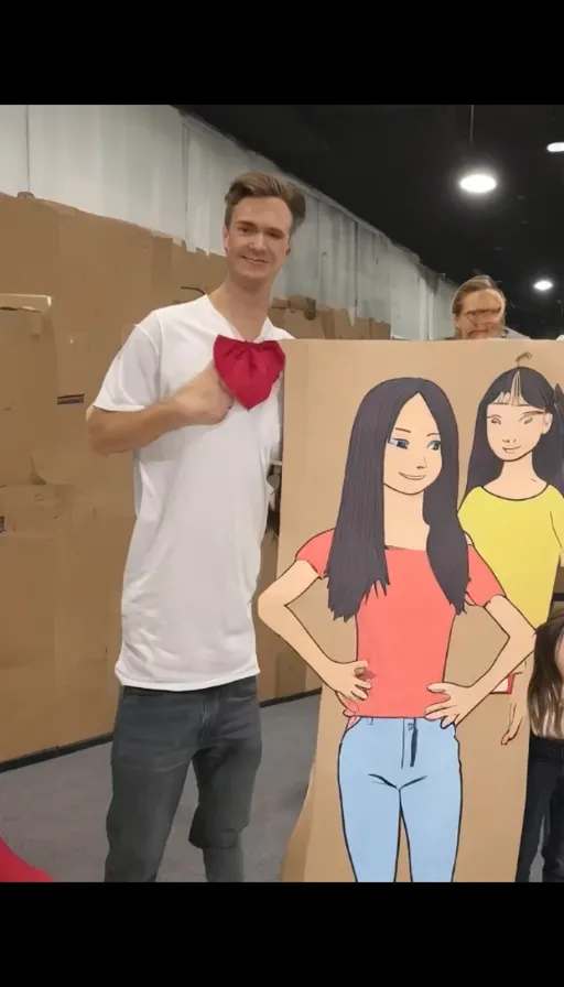 A man next to a cardboard cutout of two women changes women into landscape. a man next to a bord drew women change into landscape