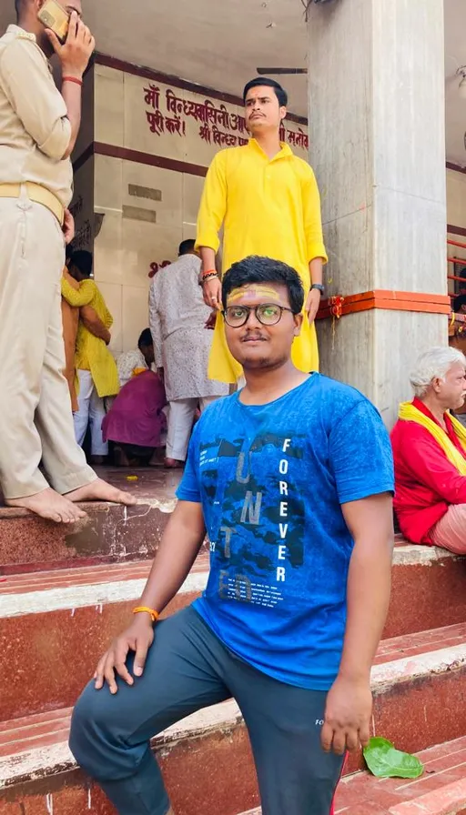 a man in a blue shirt is sitting on some steps