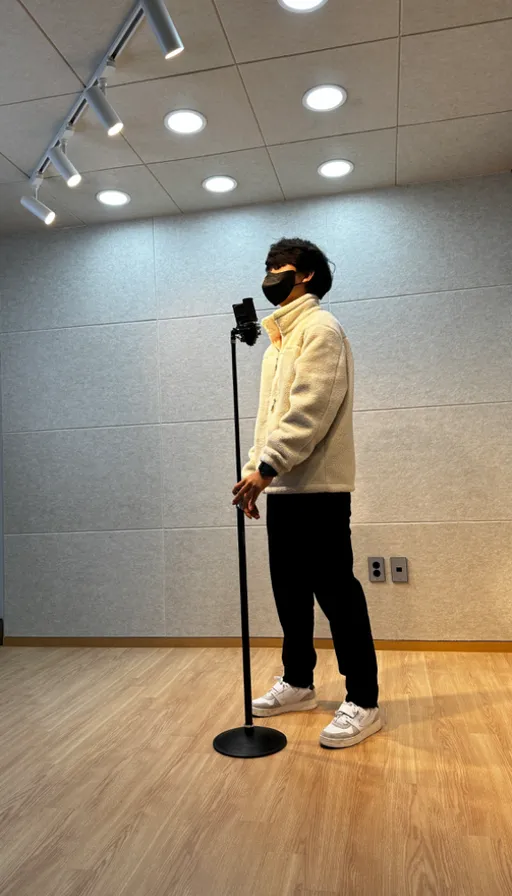 a man standing on a hard wood floor wearing a face mask