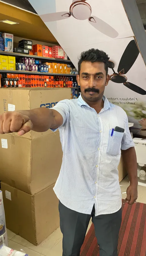 a man standing in a store pointing at the camera