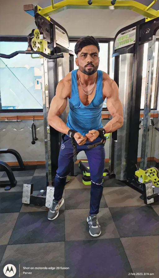 a man standing in a gym holding a rope