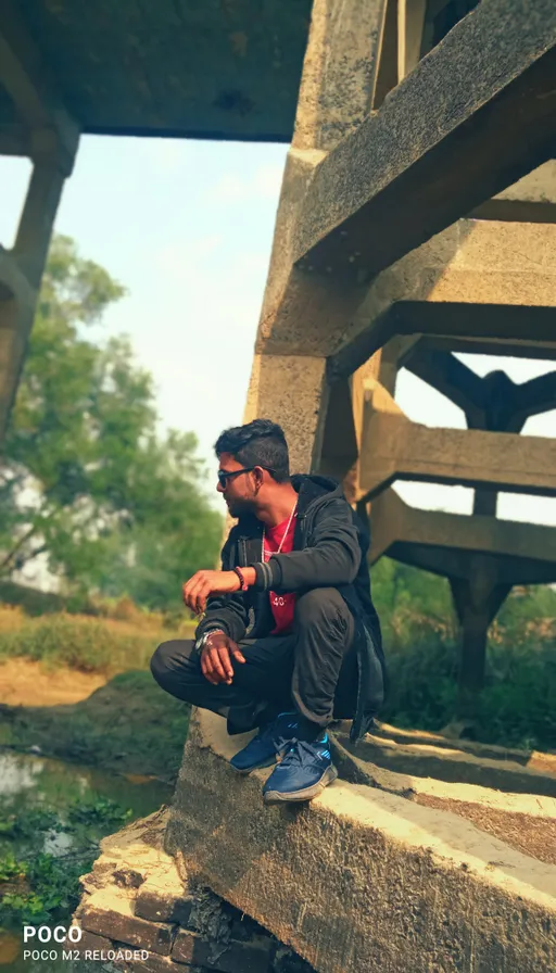 a man sitting on top of a cement structure