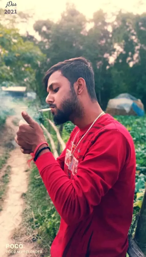 a man sitting on a bench smoking a cigarette