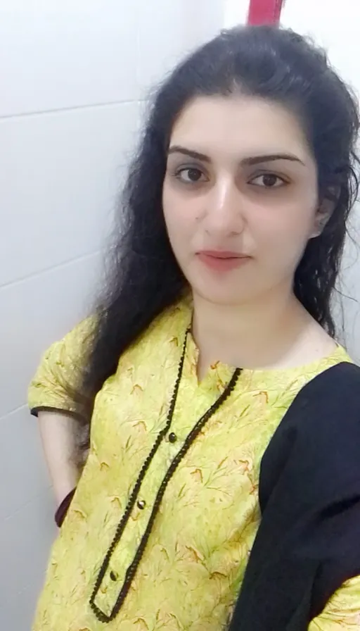 a woman with long black hair wearing a yellow top