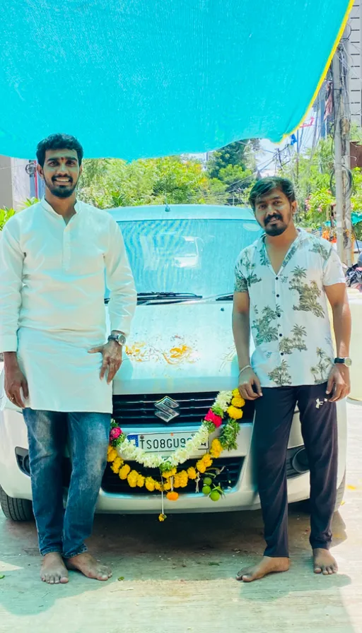 two men standing next to a white car