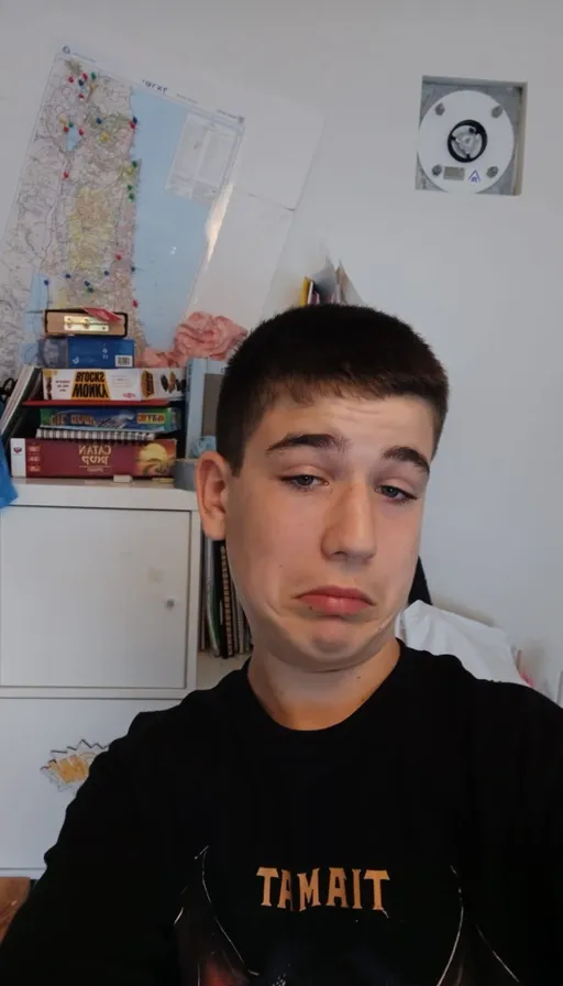 a young man sitting in a room with a map on the wall