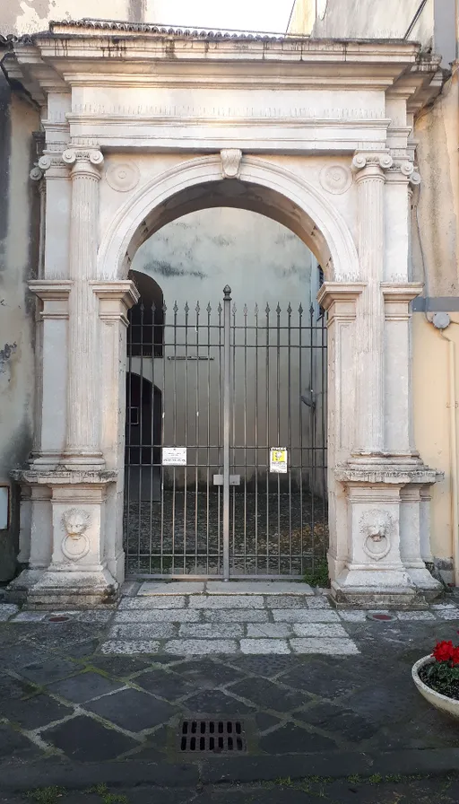 an old building with a gate and a potted plant