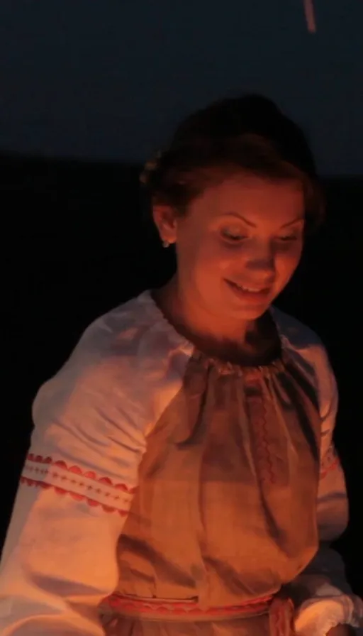 a woman in a white dress holding a lit candle