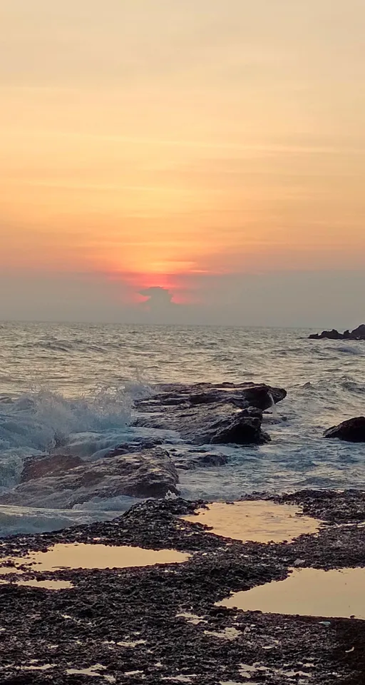 the sun is setting over the water at the beach