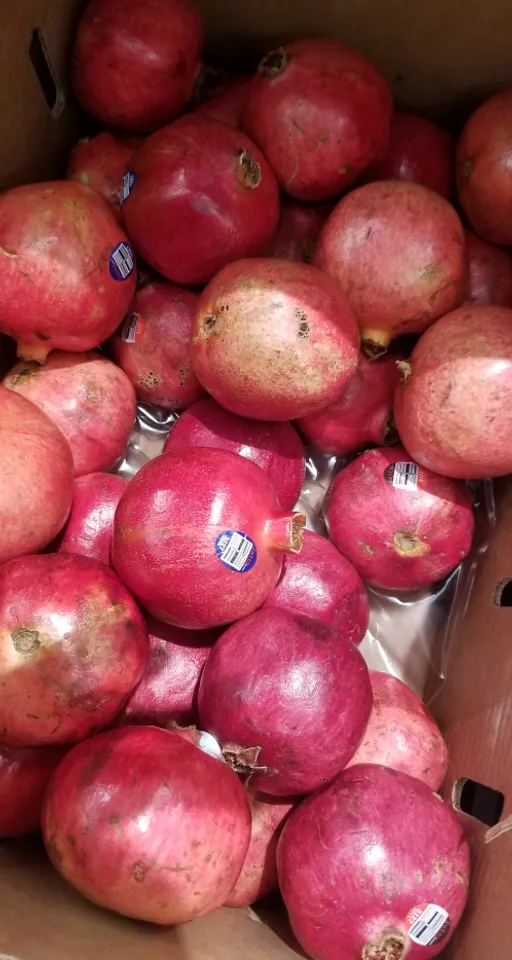 a box filled with lots of pomegranates. food, plant, fruit, natural foods, staple food, ingredient, mcintosh, whole food, produce, superfood