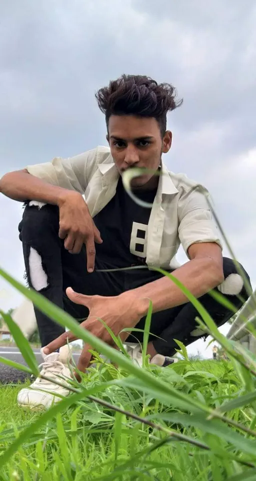 a man sitting in the grass pointing at something