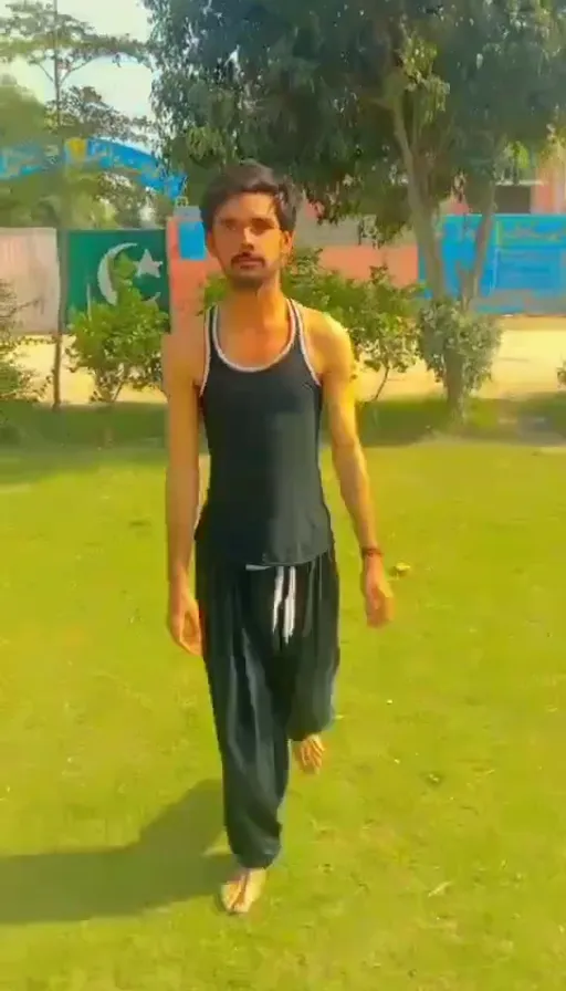 a man in a black tank top and green pants