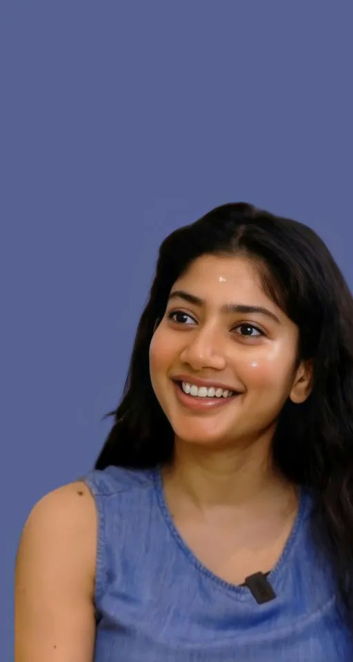 a woman with long black hair smiling at the camera