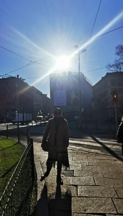 a person walking down a sidewalk with a suitcase