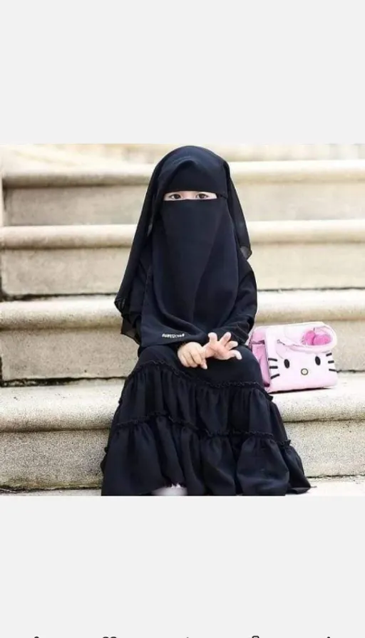 a woman in a black hijab sitting on some steps