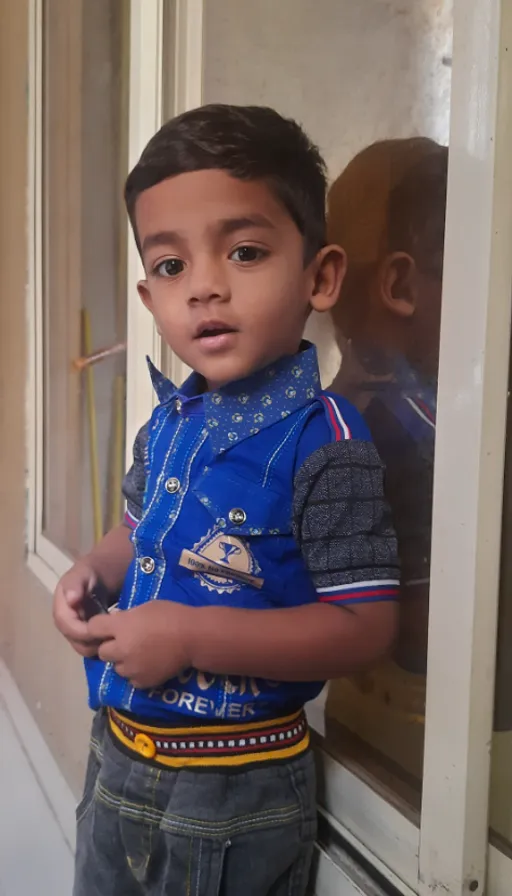 a young boy standing in front of a window