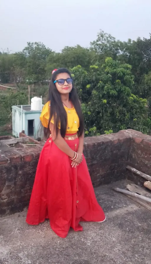 a woman in a yellow top and red skirt