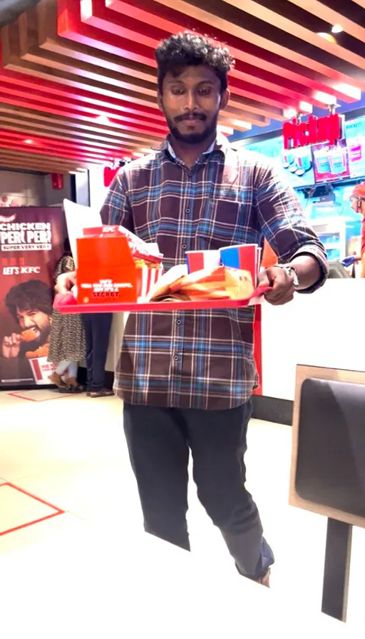 a man is holding a box of hot dogs