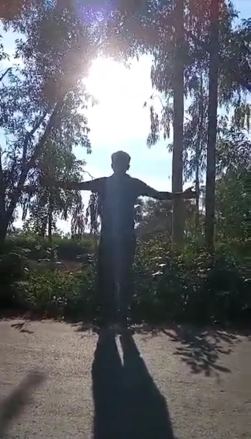 a man standing in the middle of a road with his arms outstretched