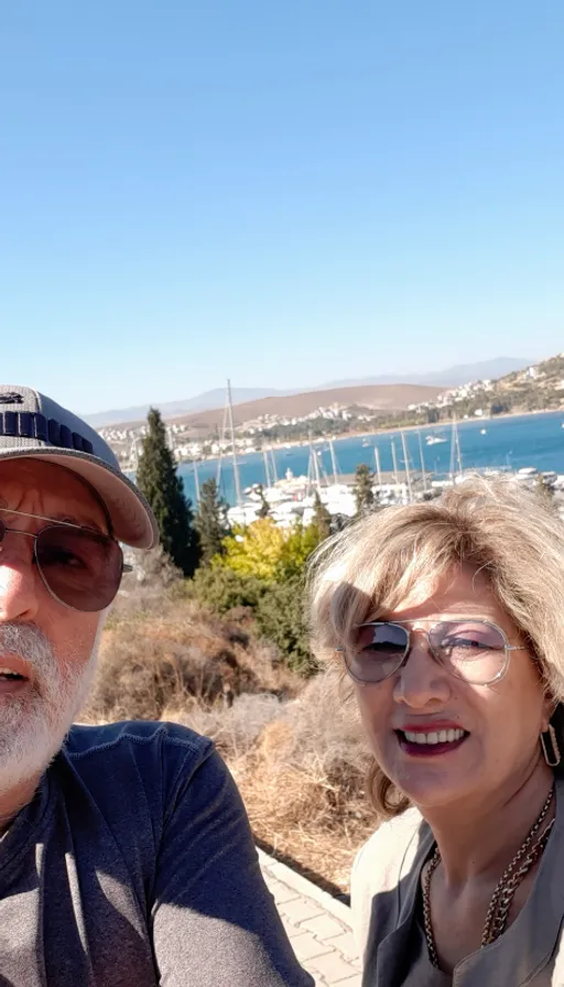 a man and a woman taking a selfie. sky, water, glasses, smile, plant, eyewear, vision care, travel, tree, leisure