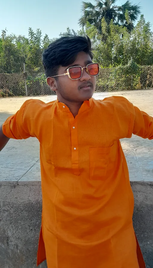 a young man in an orange shirt and sunglasses