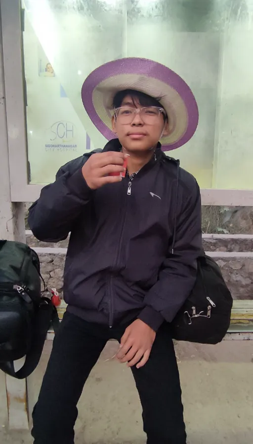 a man sitting on a bench wearing a hat