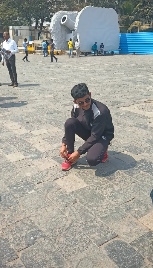 a man kneeling down on the ground with a shoe in his hand