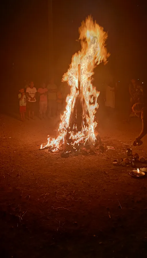 a man standing in front of a fire in the middle of a field