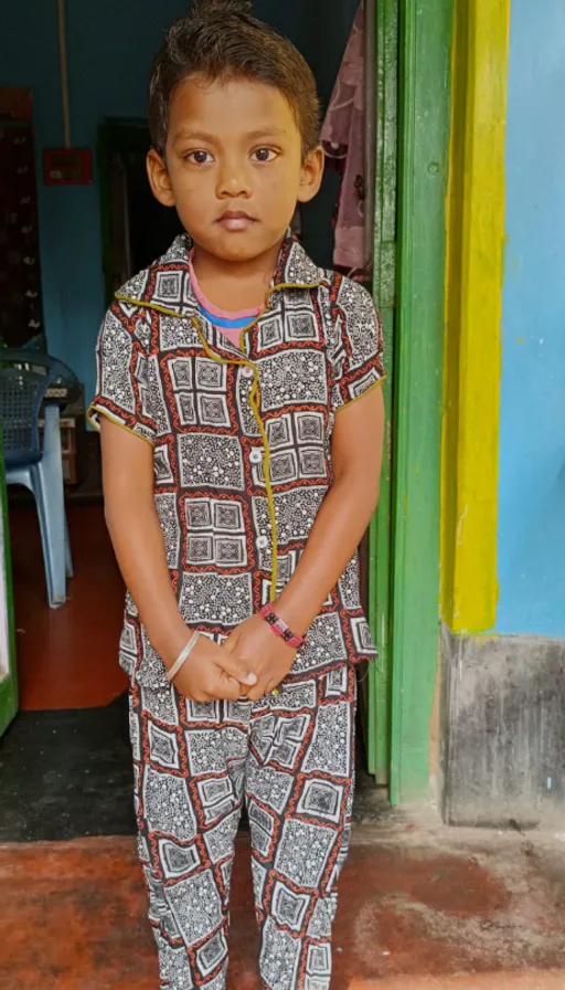 a young boy standing in front of a doorway