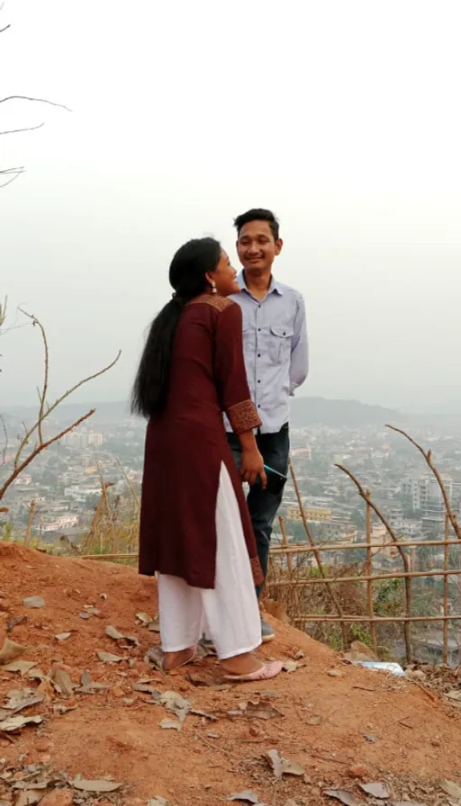 a man and a woman standing on top of a hill