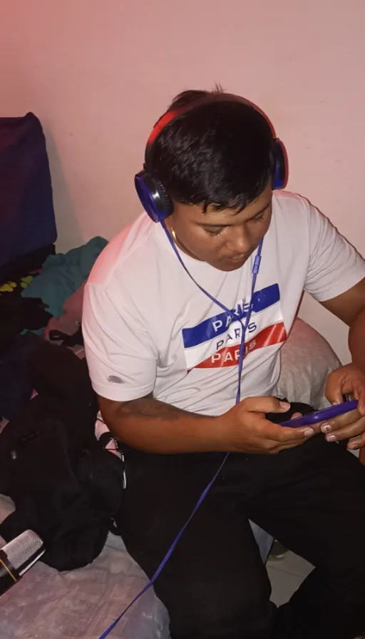 a man sitting on a bed with headphones on