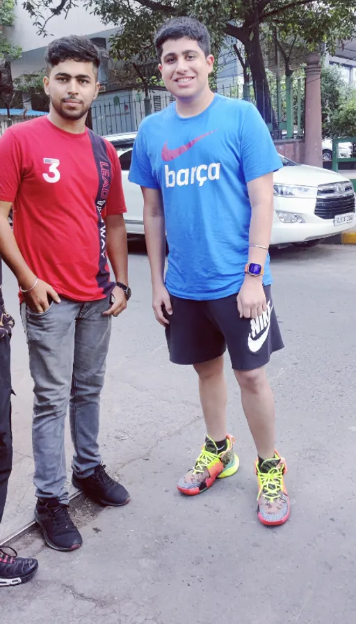 two men standing next to each other on a street