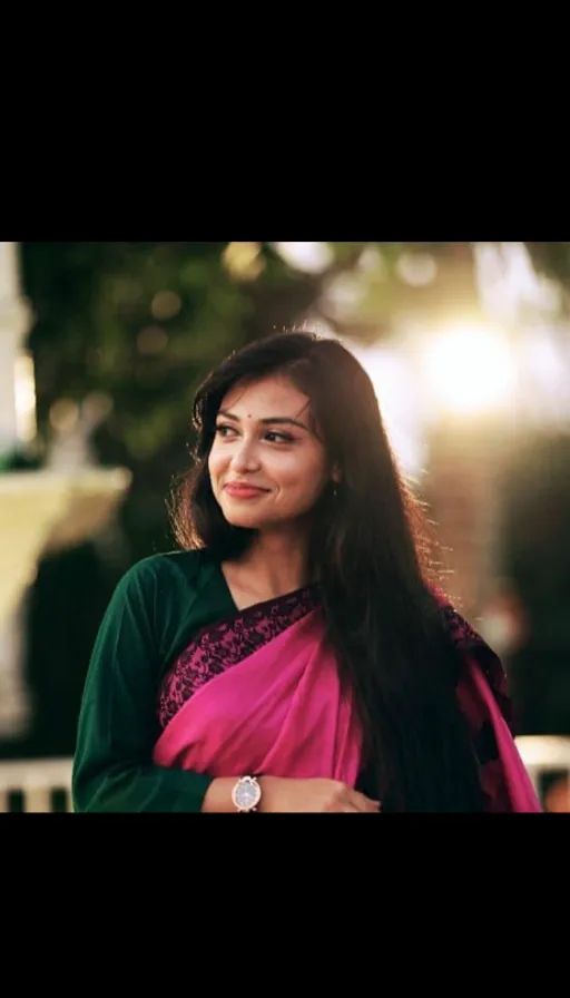 wearing a pink and green sari, and having long hair. a woman with short hair wearing a blue and white polo shirt