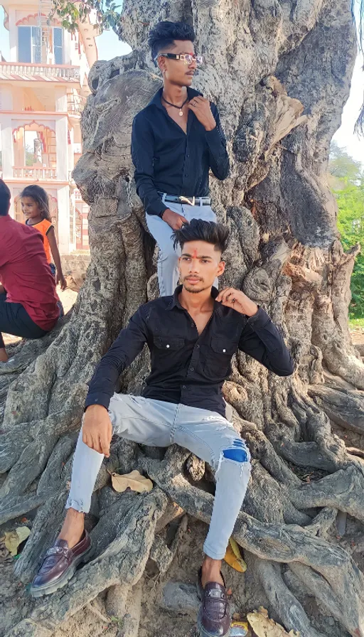 two men sitting on top of a tree